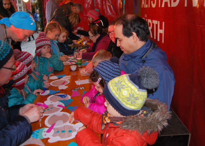 Die United Kiltrunners und Running Angel Susanne Singer basteln mit Kindern auf der Fürther Altstadtweihnacht